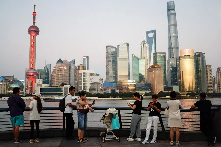 People enjoying the view on the Bund near the financial district of Pudong, in Shanghai, China, on 27 September 2024. (Tingshu Wang/Reuters)