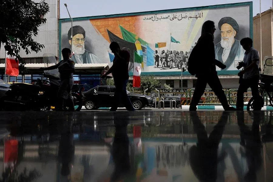 People walk past a mural of Iran's Supreme Leader Ayatollah Ali Khamenei on a street during the early hours of a ceasefire with Israel after 12 days of war, in Tehran, Iran, 24 June 2025.