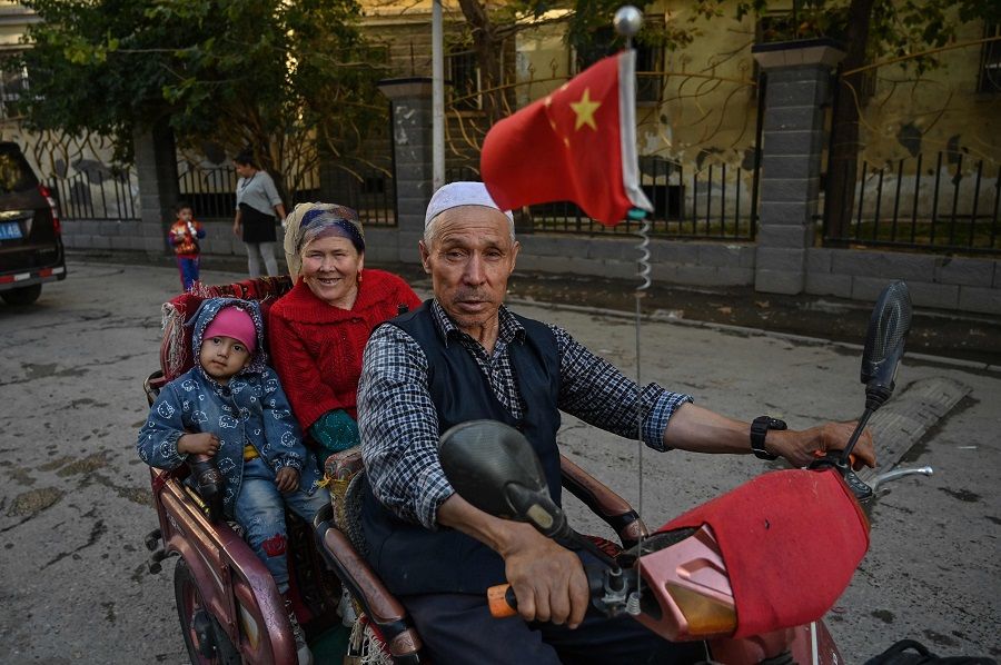 This file photo taken on 11 September 2019 shows a man driving a vehicle in an ethnic Uighur neighbourhood in Aksu in the region of Xinjiang. (Hector Retamal/AFP)