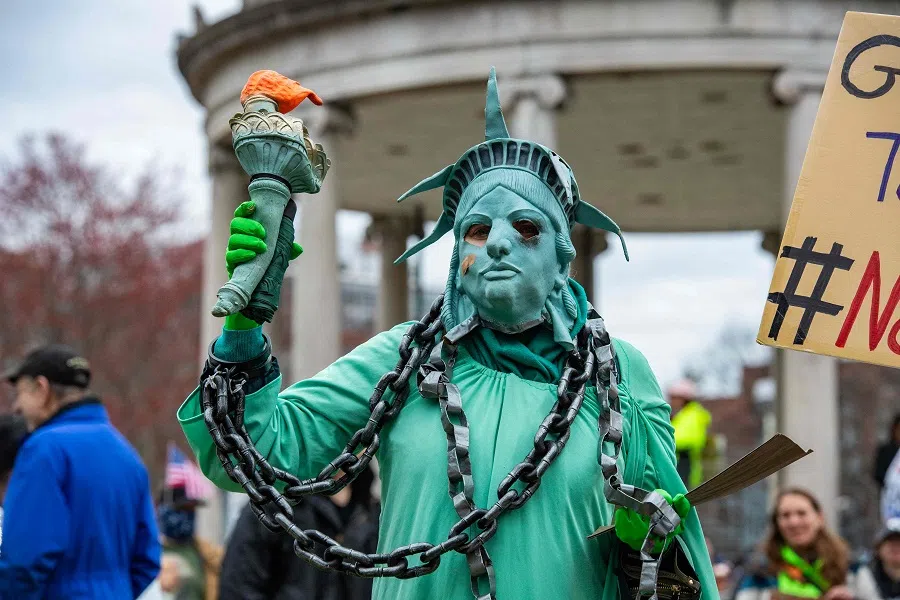 A demonstrator dressed as a Statue of Liberty in chains takes part in the nationwide “Hands Off!” protest against US President Donald Trump and his adviser, Tesla CEO Elon Musk, in Boston, Massachusetts, US, on 5 April 2025.
