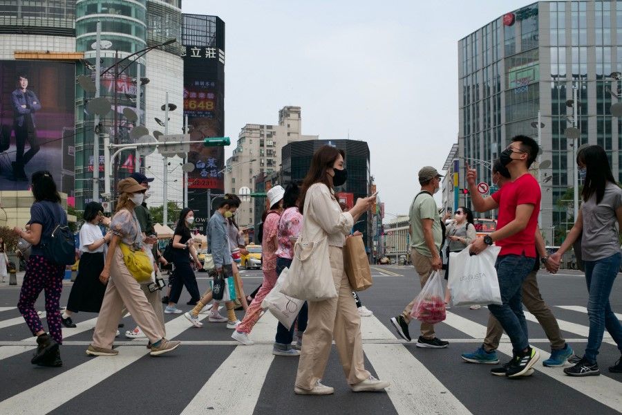 This picture taken on 14 April 2023 shows people walking down a street at the Ximen district in Taipei. (Sam Yeh/AFP)