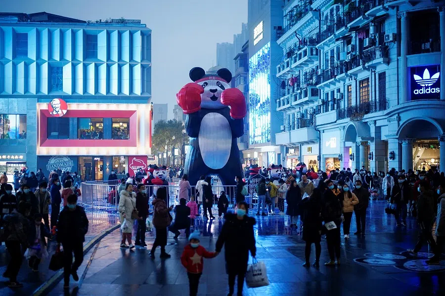 People wearing face masks are seen at a shopping area almost a year after the global outbreak of the Covid-19 in Wuhan, Hubei province, China, 6 December 2020. (Aly Song/Reuters)