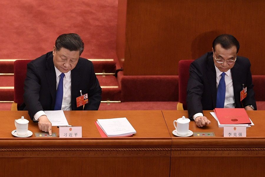 Chinese President Xi Jinping (left) and Premier Li Keqiang vote on a proposal to draft a security law on Hong Kong during the closing session of the National People's Congress at the Great Hall of the People in Beijing on 28 May 2020. (Nicolas Asfouri/AFP)