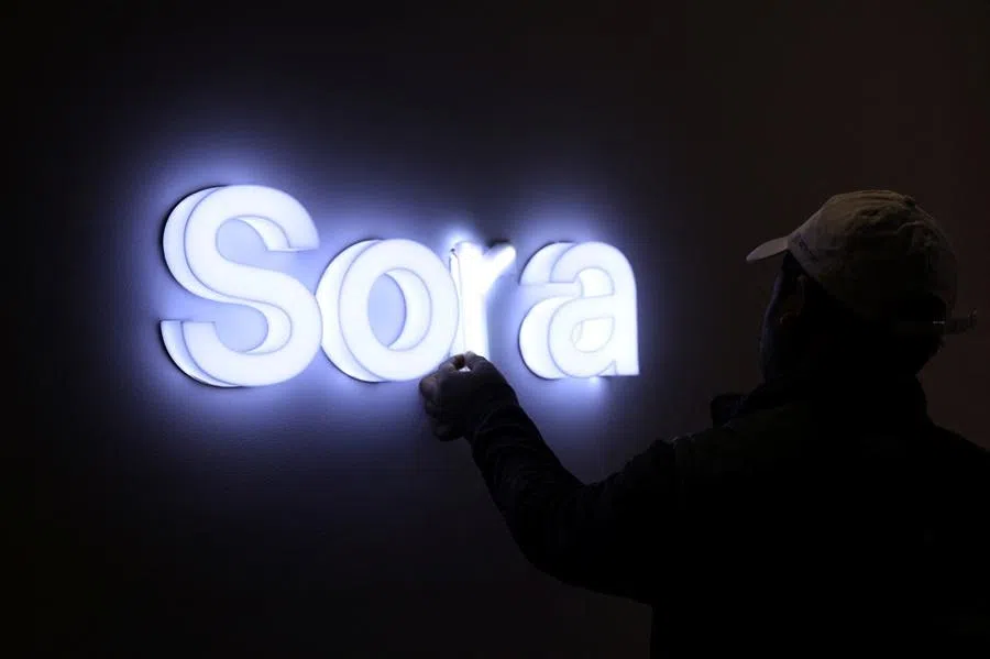 A worker fixes lights on a sign of Sora, an AI video-generating app, at Bharat Mandapam, one of the venues for AI Impact Summit, in New Delhi, India, on 16 February 2026.