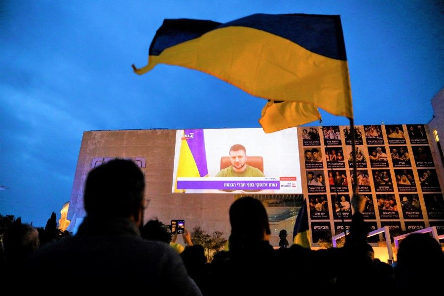 Demonstrators gather in support of Ukraine following Russia's invasion, and watch Ukraine President Volodymyr Zelensky's speech as it is broadcasted to the Knesset, Israel's parliament, and projected at Habima Square in Tel Aviv, Israel, 20 March 2022. (Corinna Kern/Reuters)