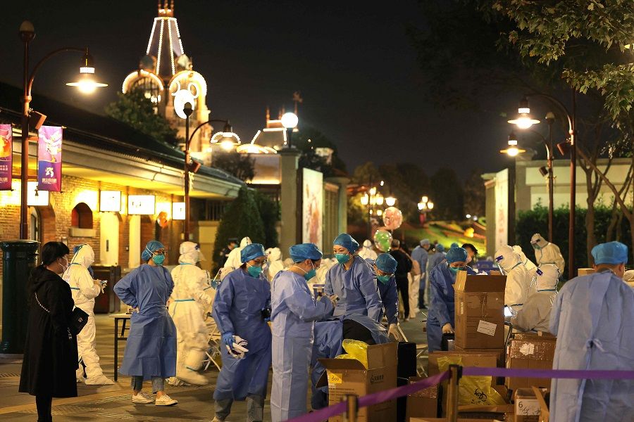 This photo taken on 31 October 2021 shows medical personnel preparing to test visitors for the Covid-19 coronavirus at Disneyland in Shanghai, China. (AFP)