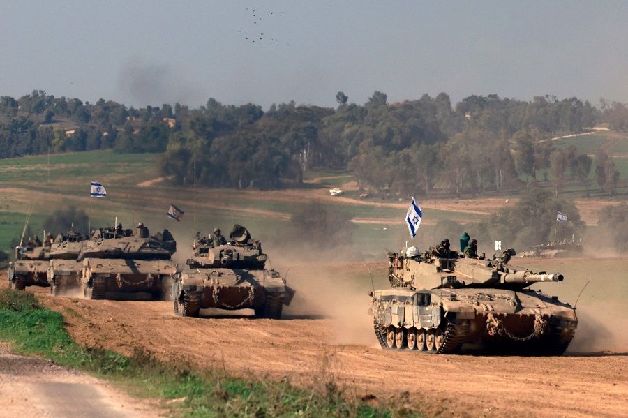 This photograph taken in Israel near the border with the Gaza Strip shows Israeli troops on tanks rolling back from the Gaza Strip, on 31 December 2023 amid continuing battles between Israel and the militant group Hamas. (Menahem Kahana/AFP)