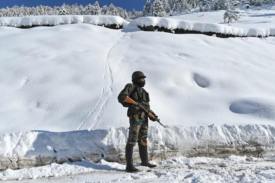 Indian army soldier stands on a snow-covered road near Zojila mountain pass that connects Srinagar to the union territory of Ladakh, bordering China, 28 February 2021.