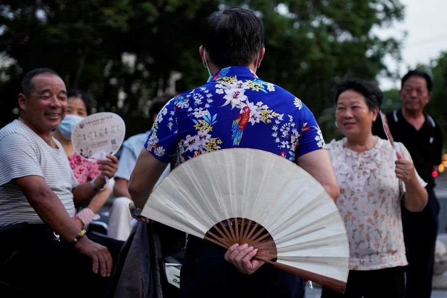 People use fans as they chat in a park amid a heatwave warning in Shanghai, China, 23 July 2022. (Aly Song/Reuters)