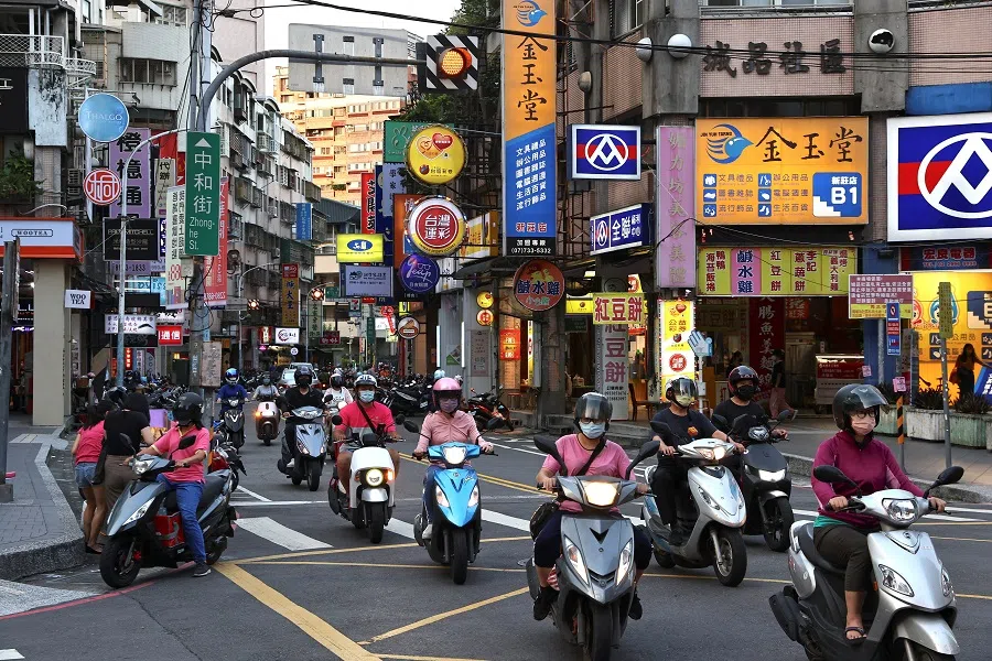 People ride their motorbikes during sunset hours in New Taipei City, Taiwan, 14 July 2022. (Ann Wang/Reuters)