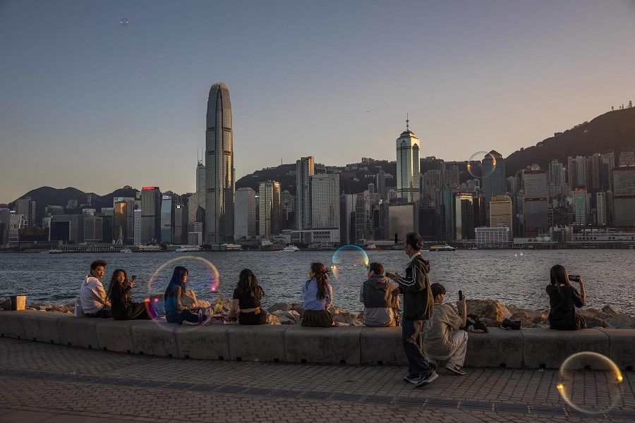 People visit a promenade next to Victoria Harbour in Hong Kong on 18 January 2024. (Dale de la Rey/AFP)