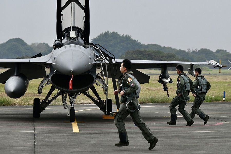 Taiwanese air force pilots run past an armed US-made F-16V fighter at an air force base in Chiayi, Taiwan on 5 January 2022. (Sam Yeh/AFP)