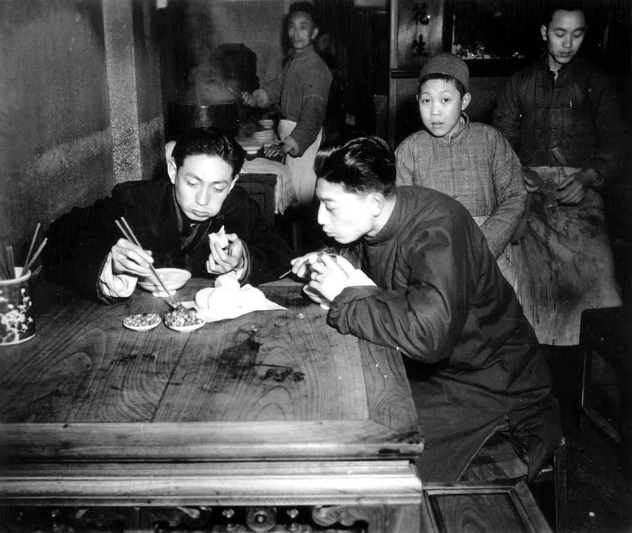 Shanghainese having a chat over porridge and buns for breakfast. The routine: wake up, have breakfast, go to work, meet friends, gossip, then say goodbye, and go to bed. No matter how politics changes, the life of the man on the street does not.