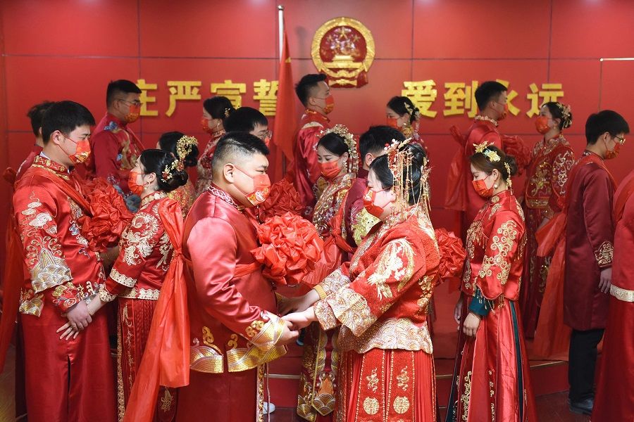 Couples attend a group wedding ceremony at a marriage registry in Donghai, Jiangsu province, China, on 22 February 2022, a palindrome day written as "22-2-22". (AFP)