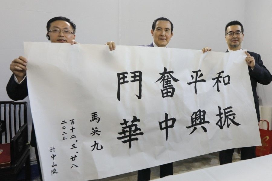 This handout picture taken and released by the office of former Taiwanese President Ma Ying-jeou on 28 March 2023 shows former Taiwanese President Ma Ying-jeou (centre) holding a written calligraphy reading "Peaceful struggle and revitalisation of Zhonghua" during his visit to Dr. Sun Yat-sen's Mausoleum in Nanjing, in China's eastern Jiangsu province. (Handout/Ma Ying-jeou's office/AFP)