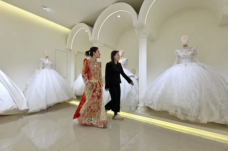 A woman checks her wedding dress at a bridal shop in Luliang, northern China’s Shanxi province on 11 February 2025. (Adek Berry/AFP)