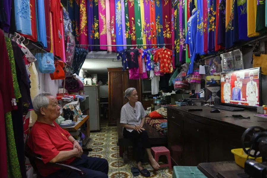 People watch on TV the speech of Vietnam's former Prime Minister Nguyen Xuan Phuc, who became a new president, during an official ceremony in Hanoi, Vietnam, 5 April 2021. (Thanh Hue/Reuters)
