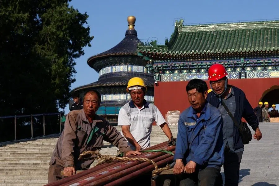 Construction workers pull a trolley with parts of scaffolding next to the Hall of Prayer for Good Harvests at the Temple of Heaven, in Beijing, China, on 11 May 2026. (Maxim Shemetov/Reuters)