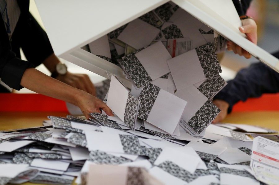 Officials open a ballot box at a polling station in Kowloon Tong, Hong Kong. (Athit Perawongmetha/REUTERS)