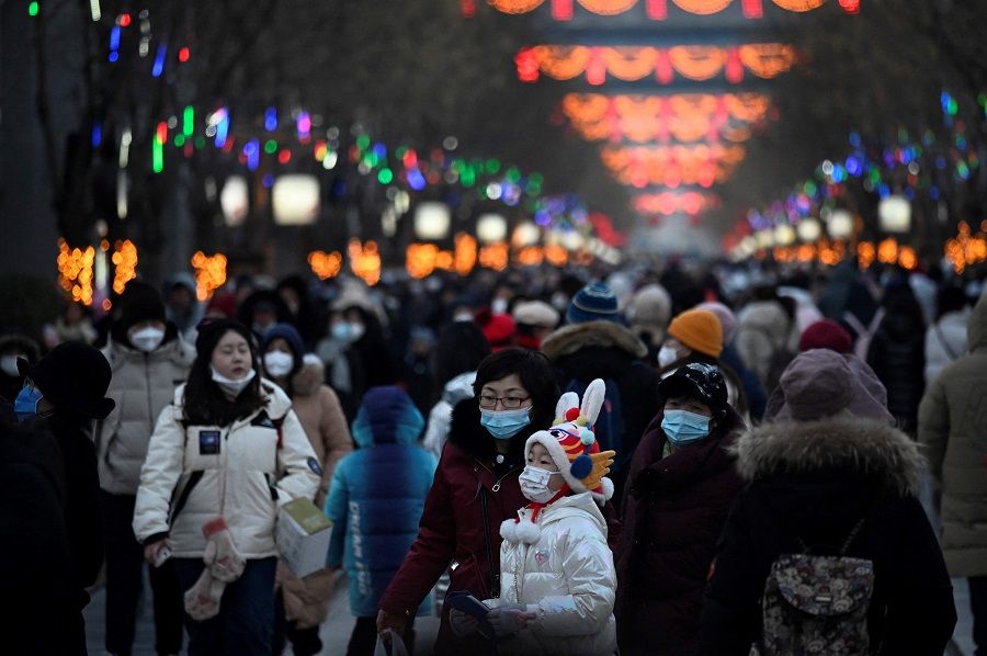 People visit a business street during the Lunar New Year in Beijing, China, on 25 January 2023. (Wang Zhao/AFP)
