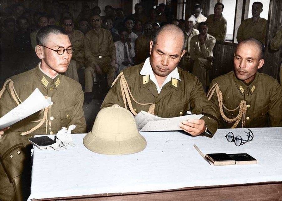 Vice-chief of the general staff of the China Expeditionary Army Takeo Imai (centre) accepting on behalf of the Japanese army the order to surrender from the Chinese representative, 21 August 1945.