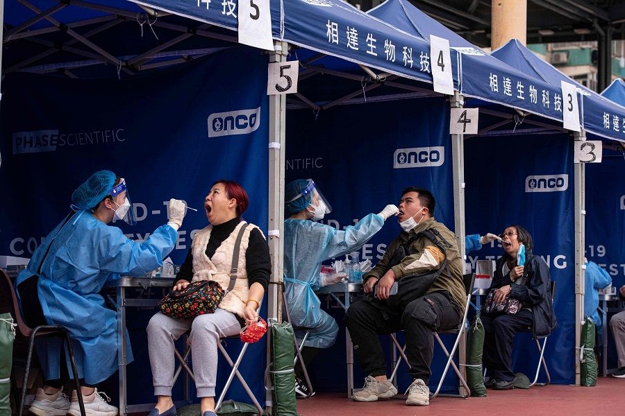 People are tested at a temporary testing site for Covid-19 in Hong Kong on 12 February 2022, as authorities scrambled to ramp up testing capacity following a record high of new infections. (Louise Delmotte/AFP)