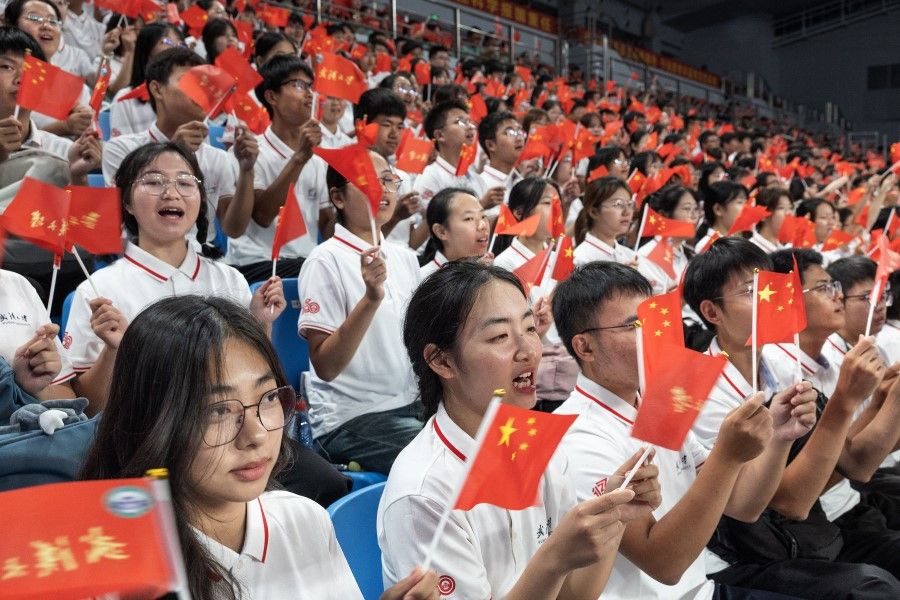 Students wave the national flag of China during an opening ceremony for undergraduates at the Wuhan University in Wuhan on 12 September 2023. (AFP)