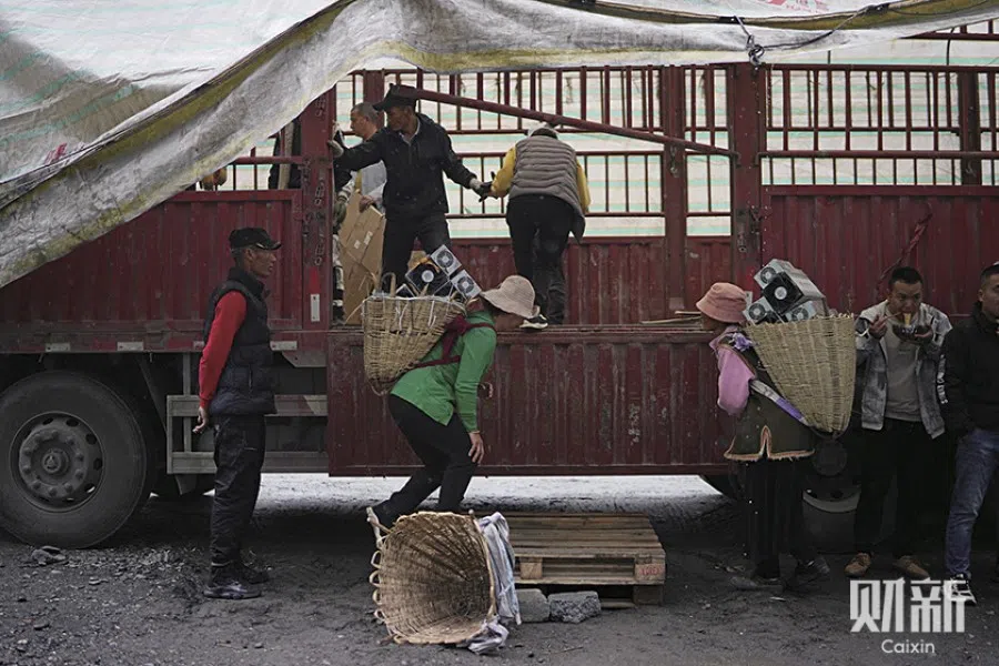 Villagers load a truck with the removed mining machines on 21 June 2021. (Ding Gang/Caixin)
