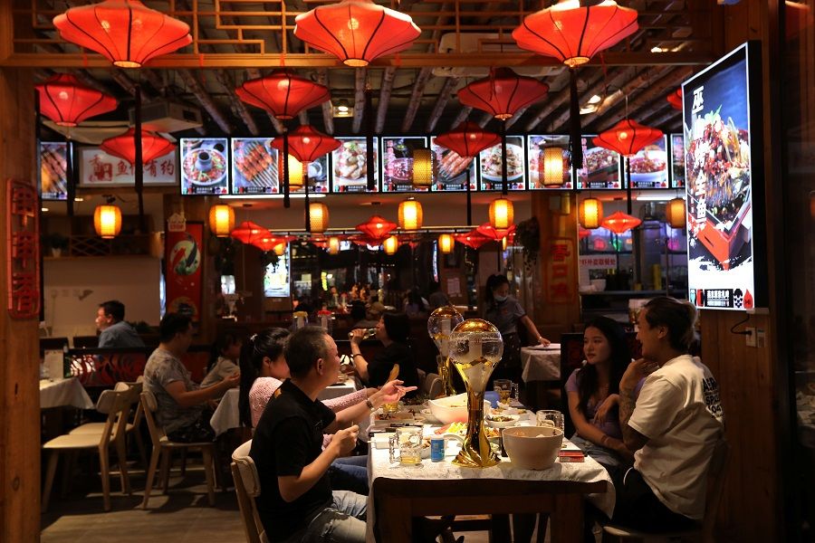 People dine at a restaurant in Beijing, China, 13 August 2021. (Tingshu Wang/Reuters)