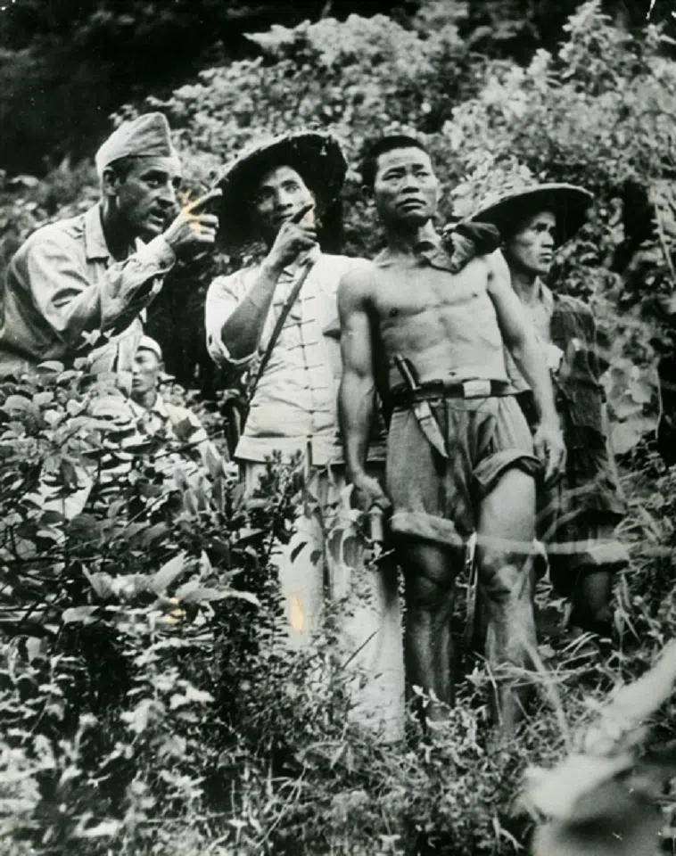 A photo taken by LIFE magazine reporter Jack Wilkes on 27 July 1945 showing US military advisor Claude E. Davis training Chinese guerrillas in Guangxi, before recapturing Liuzhou Airport during a counteroffensive.
