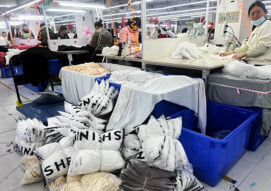 Workers work at a production line manufacturing clothing for Shein at a factory in Guangzhou, Guangdong province, China, on 1 April 2025. (Casey Hall/Reuters)