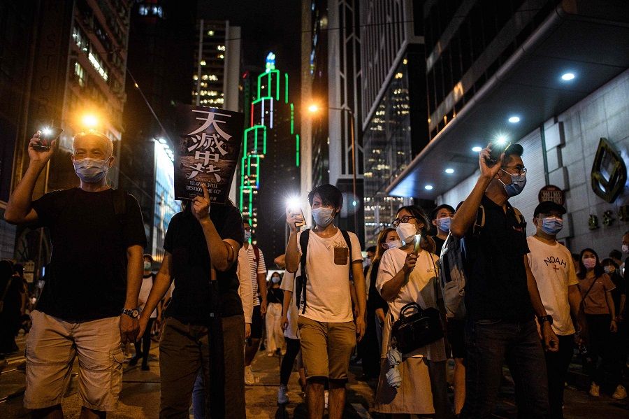 Pro-democracy protesters march in the Central district of Hong Kong on 9 June 2020, as the city marks the one-year anniversary since pro-democracy protests erupted following opposition to a bill allowing extraditions to mainland China. (Anthony Wallace/AFP)