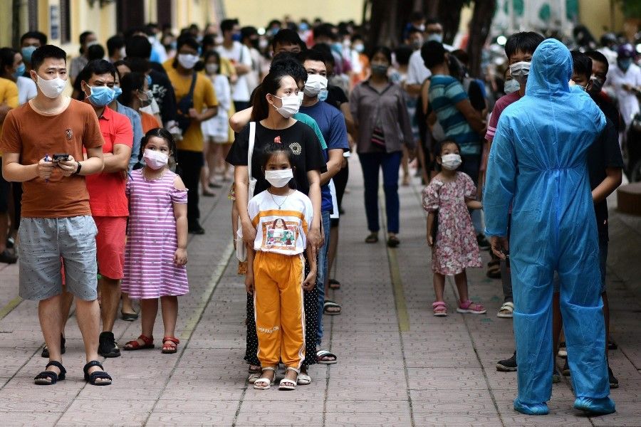 People observe social distancing while waiting to be tested at a makeshift rapid testing centre in Hanoi on 1 August 2020, as Vietnam records a rise in cases of the Covic-19 coronavirus.(Manan Vatsyayana/AFP)