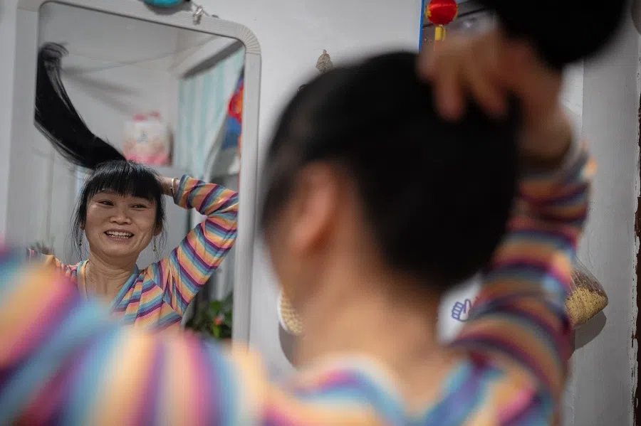 In the early morning, Sister Chen washes up in her rented lodgings in Beijing, preparing to go home to Sichuan.
