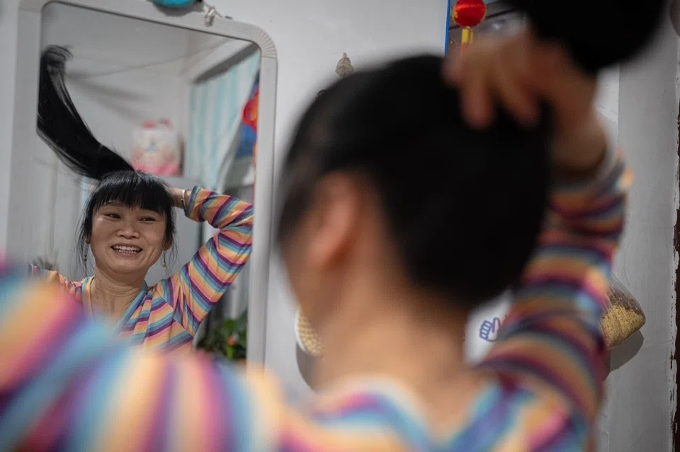 In the early morning, Sister Chen washes up in her rented lodgings in Beijing, preparing to go home to Sichuan.