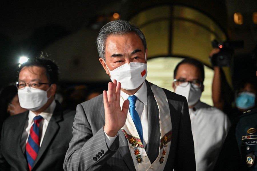 Chinese Foreign Minister Wang Yi gestures upon arriving for an official visit to the Philippines, at Villamor Airbase in Pasay, Metro Manila, on 5 July 2022. (Jam Sta Rosa/AFP)