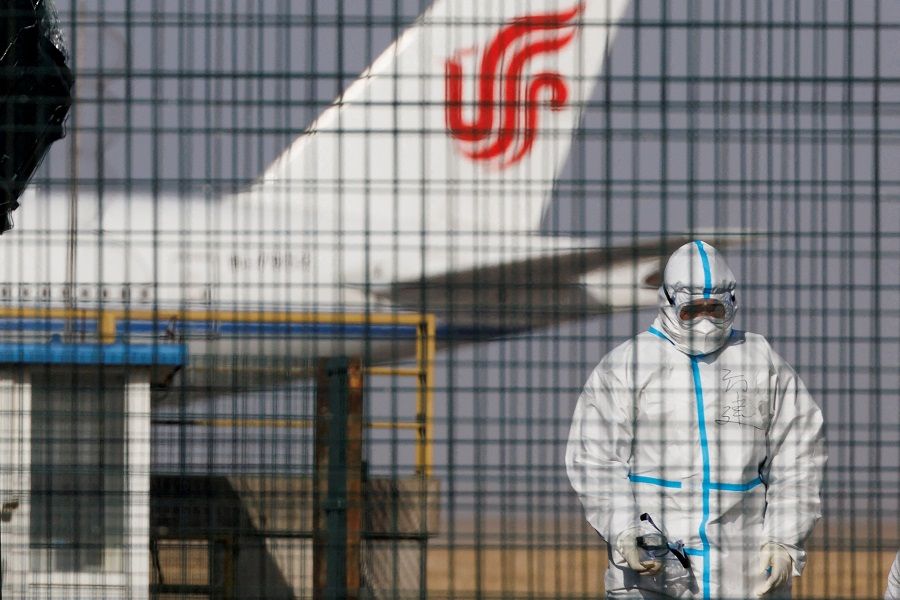 A worker in a protective suit walks near a plane of Air China airlines at Beijing Capital International Airport as Covid-19 outbreaks continue in Beijing, China, 6 January 2023. (Thomas Peter/File Photo/Reuters)