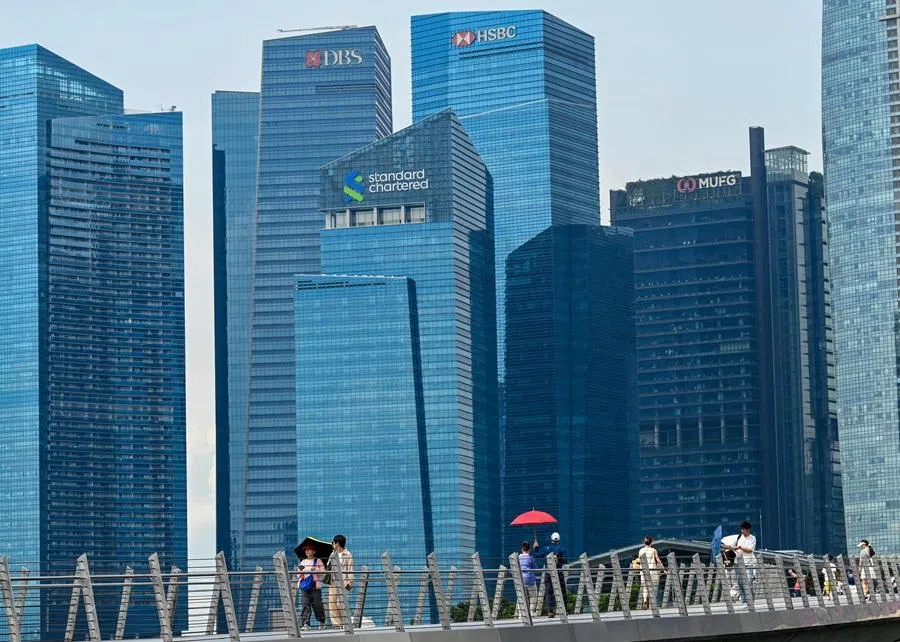 People walk across Jubilee Bridge at Marina Bay in Singapore on 5 May 2026. (Roslan Rahman/AFP)