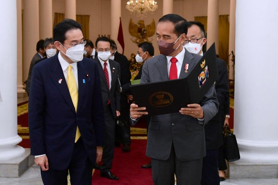 Indonesian President Joko Widodo shows Japan's Prime Minister Fumio Kishida a souvenir following their meeting at the Presidential Palace in Bogor, Indonesia, 29 April 2022. (Muchlis Jr./Indonesia's Presidential Palace/Handout via Reuters)