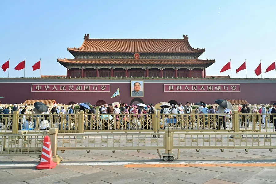 People walk past the portrait of late Communist leader Mao Zedong at the entrance to the Forbidden City at Tiananmen Square in Beijing, China, on 4 June 2024. (Adek Berry/AFP)