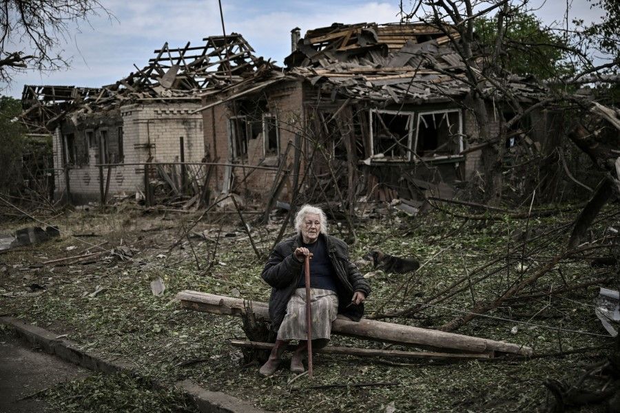 An elderly woman sits in front of destroyed houses after a missile strike, which killed an old woman, in the city of Druzhkivka (also written Druzhkovka) in the eastern Ukrainian region of Donbas on 5 June 2022. (Aris Messinis/AFP)