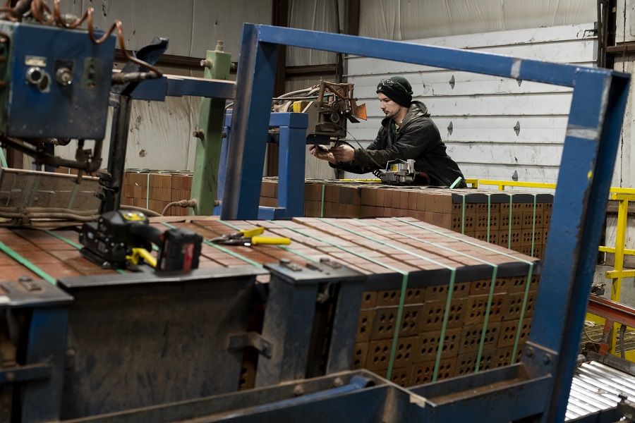 A worker wraps metal banding around pallets of fired bricks to secure them for transport at the Bowerston Shale Co. facility in Hanover, Ohio, US, on 7 January 2021. (Ty Wright/Bloomberg)