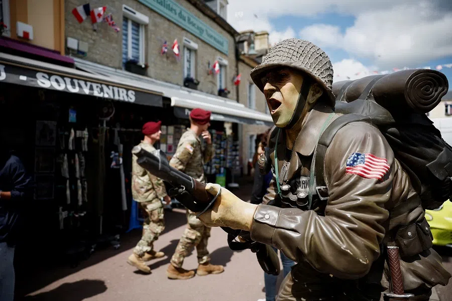 US soldiers are seen on 30 May 2024 near the church of Sainte-Mere-Eglise where John Marvin Steele, an American paratrooper landed on the pinnacle of the church tower in Sainte-Mere-Eglise, Normandy region, France. (Benoit Tessier/Reuters )