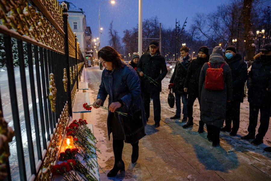 People put flowers in front of the Kazakhstan embassy in Moscow on 10 January 2022, to commemorate those killed during the recent mass protests in Kazakhstan. (Dimitar Dilkoff/AFP)