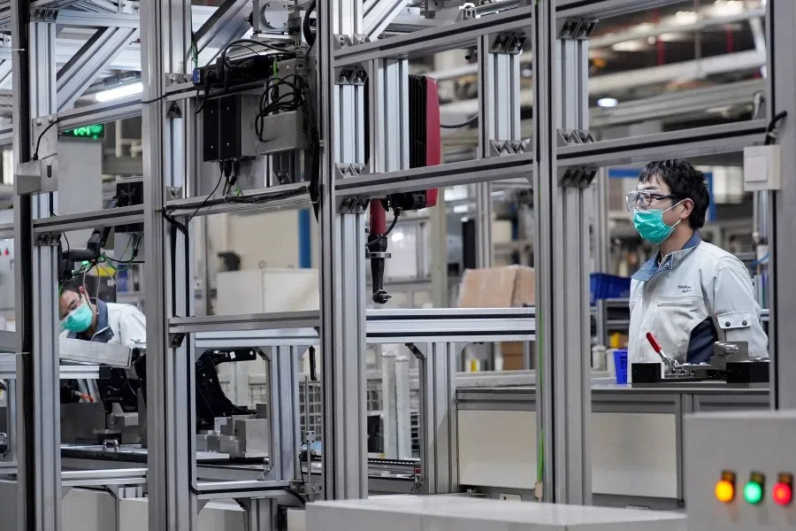Employees work on a car seat assembly line at Yanfeng Adient factory in Shanghai, February 2020. Over 90% of China's central enterprises are back in operation. (Aly Song/REUTERS)