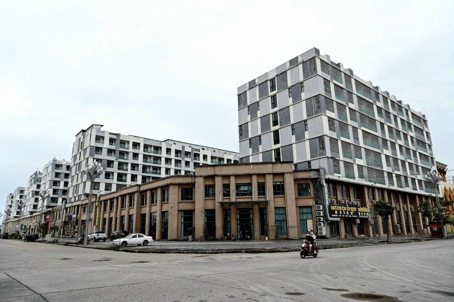 This photo taken on 25 September 2022 shows a motorist passing empty buildings in Chinatown district in Sihanoukville in Preah Sihanouk province. (AFP)