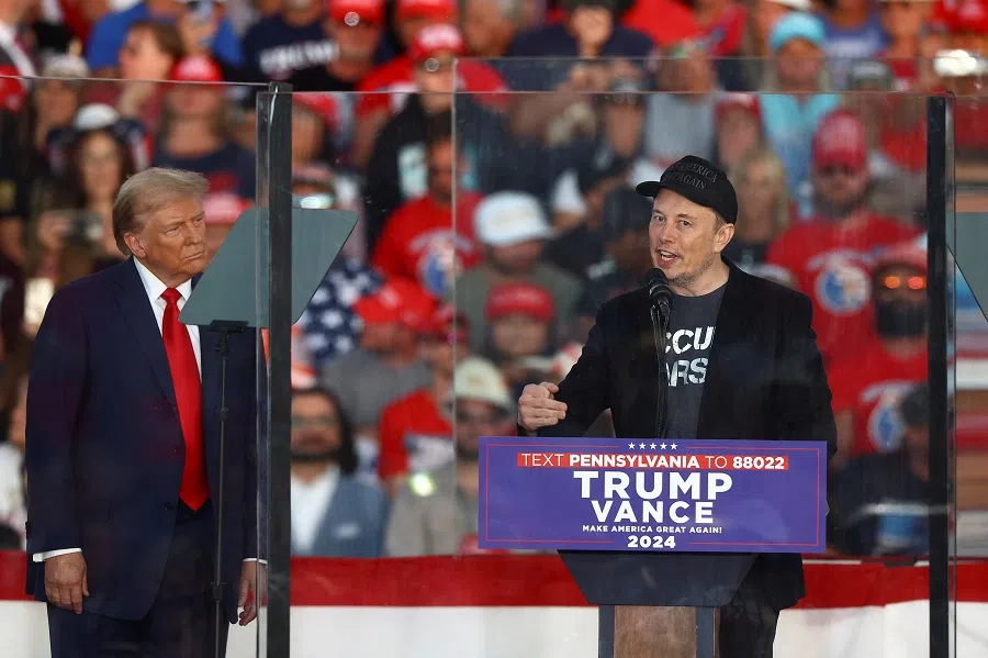 Tesla CEO and X owner Elon Musk speaks as Republican presidential nominee and former US president Donald Trump looks on during a rally at the site of the July assassination attempt against Trump, in Butler, Pennsylvania, US, on 5 October 2024. (Carlos Barria/Reuters)