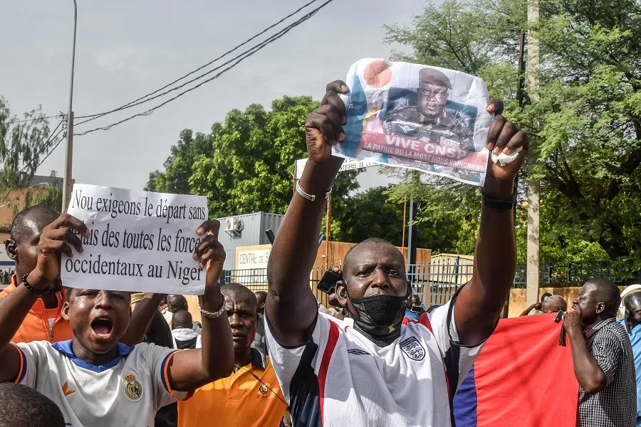 A supporter holds a picture of Niger General Abdourahamane Tiani, the chief of the powerful presidential guard, as with others rally in support of Niger's junta in Niamey on 30 July 2023. (AFP)