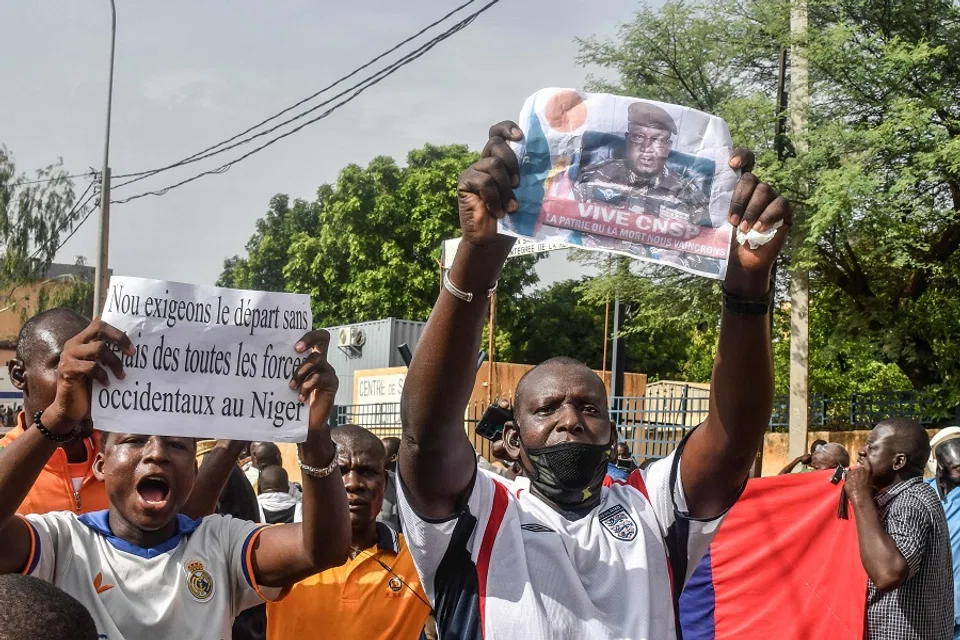 A supporter holds a picture of Niger General Abdourahamane Tiani, the chief of the powerful presidential guard, as with others rally in support of Niger's junta in Niamey on 30 July 2023. (AFP)