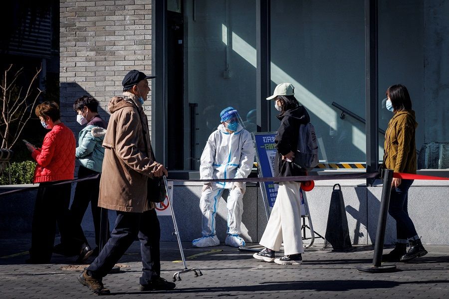 A health worker wears a protective suit near a testing booth as outbreaks of Covid-19 continue in Beijing, China, 23 October 2022. (Thomas Peter/File Photo/Reuters)